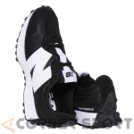 Спортни обувки New Balance в черно с бяло лого и изпъкнали детайли на петата, изглед отзад и отгоре.